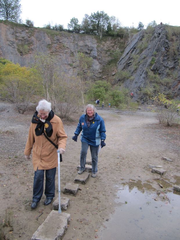 Visitors crossing the stepping stones at Fairy Cave Quarry